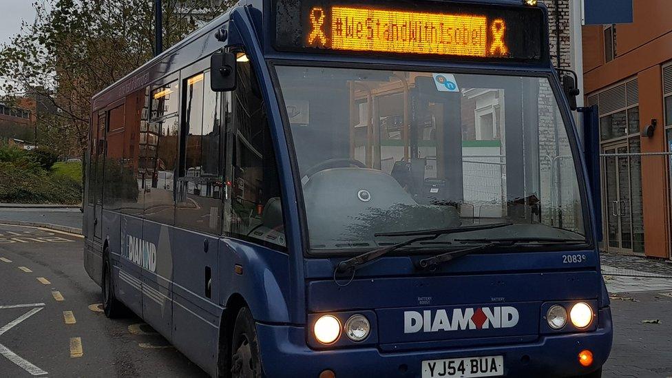 A bus with the #WeStandWithIsobel slogan