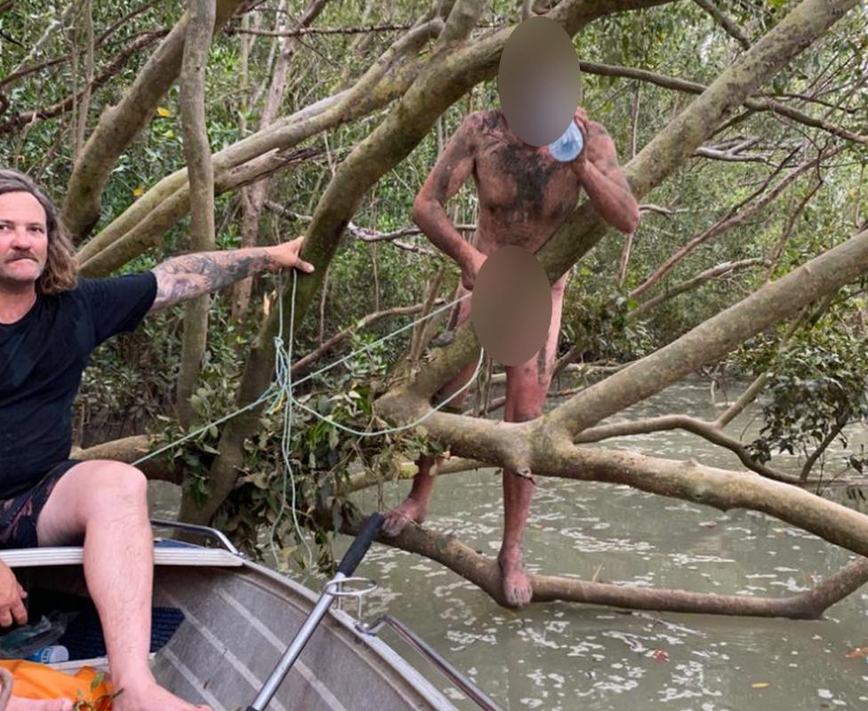 A fugitive who was found clinging to mangroves near Darwin, Australia drinks a bottle of water