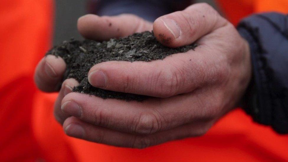 hands holding basalt dust