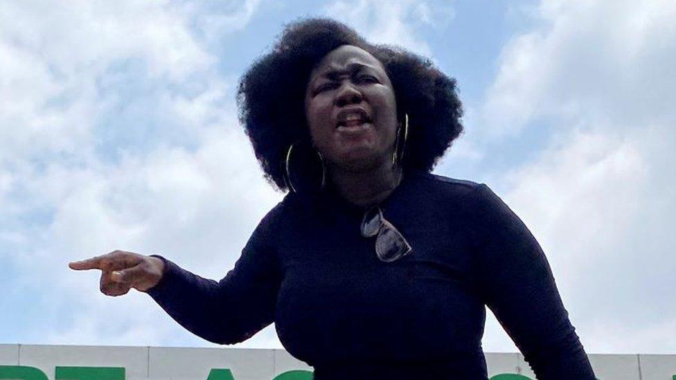 A demonstrator stands atop a vehicle and shouts slogans as others carry banners while blocking a road leading to the airport, during a protest over alleged police brutality, in Lagos, Nigeria October 12, 2020.