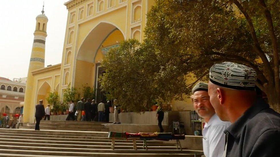 The Id Kah mosque, with worshippers passing by