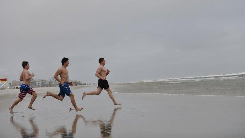 Teenagers race into the ocean on a cold day at the beach in Wildwood, New Jersey. Photo: 24 May 2020