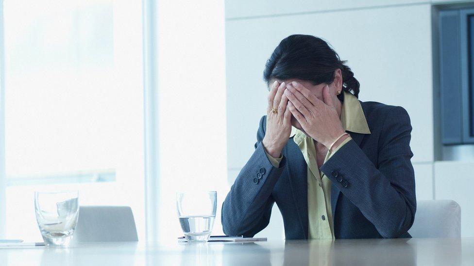 Office worker with head in hands