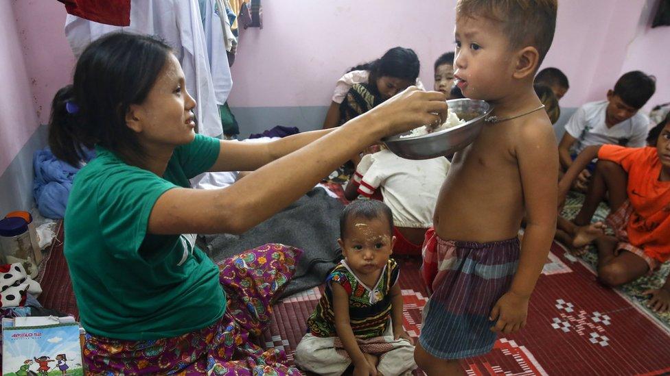 Mother feeding her child rice