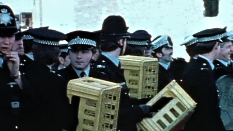 Police officers defend themselves with milk crates