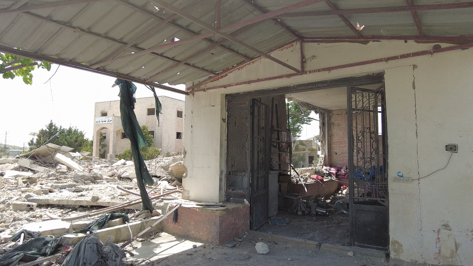 The entrance of a building surrounded by rubble