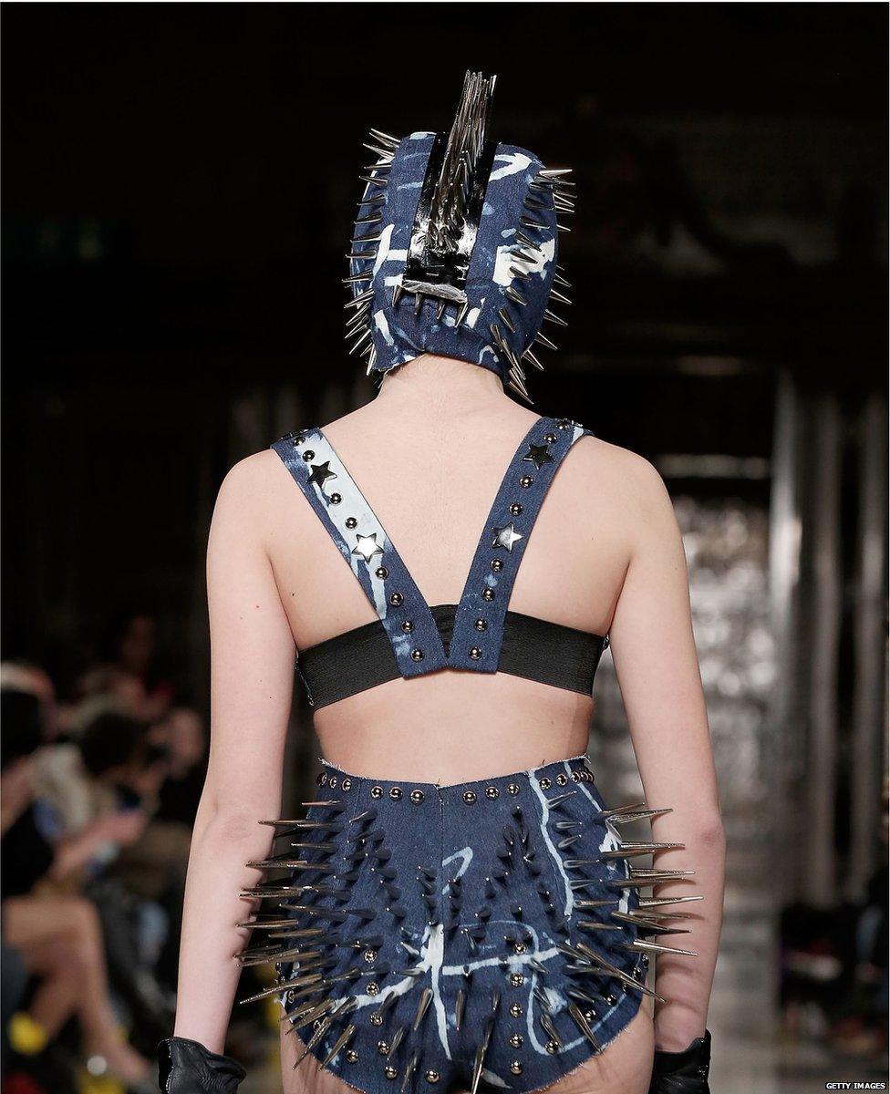 A model wearing an outfit covered in spikes