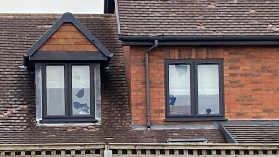 Broken windows and roof tiles on houses