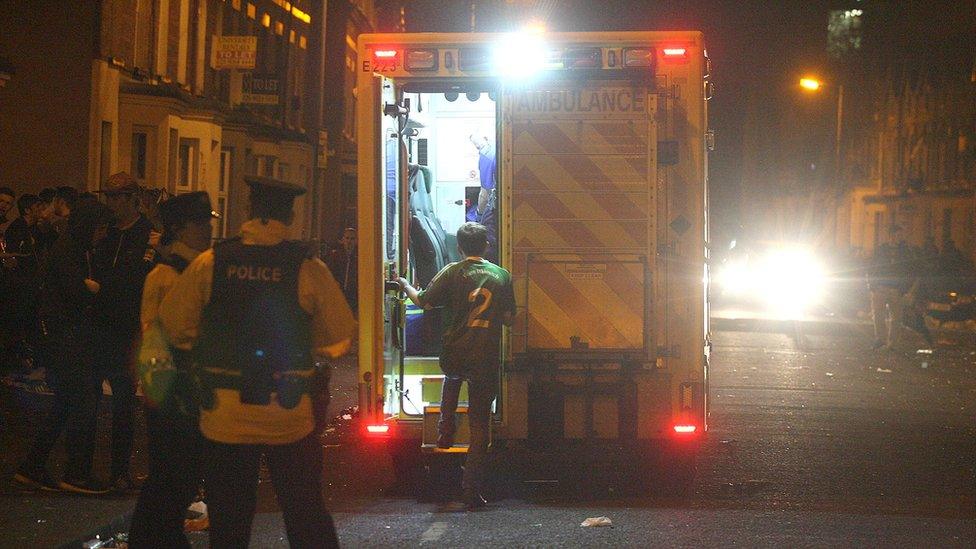 An ambulance, a police officers and a crowd of revellers in the Holyland