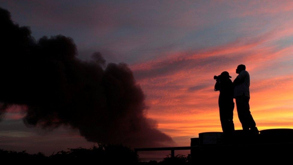 People take pictures of an explosion caused by a fire at a fuel storage tank belonging to the Puma Energy company in Puerto Sandino, Leon, Nicaragua ,2016