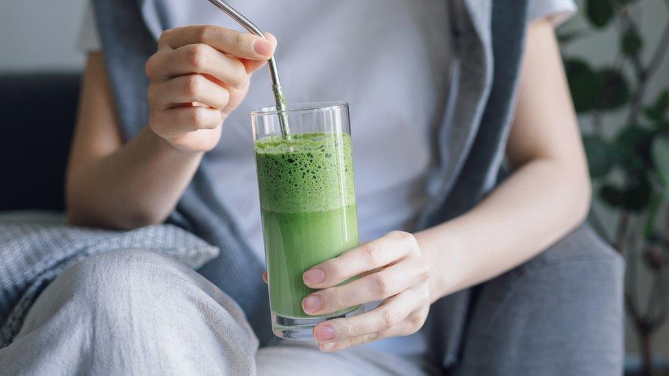 Picture of someone with a green drink