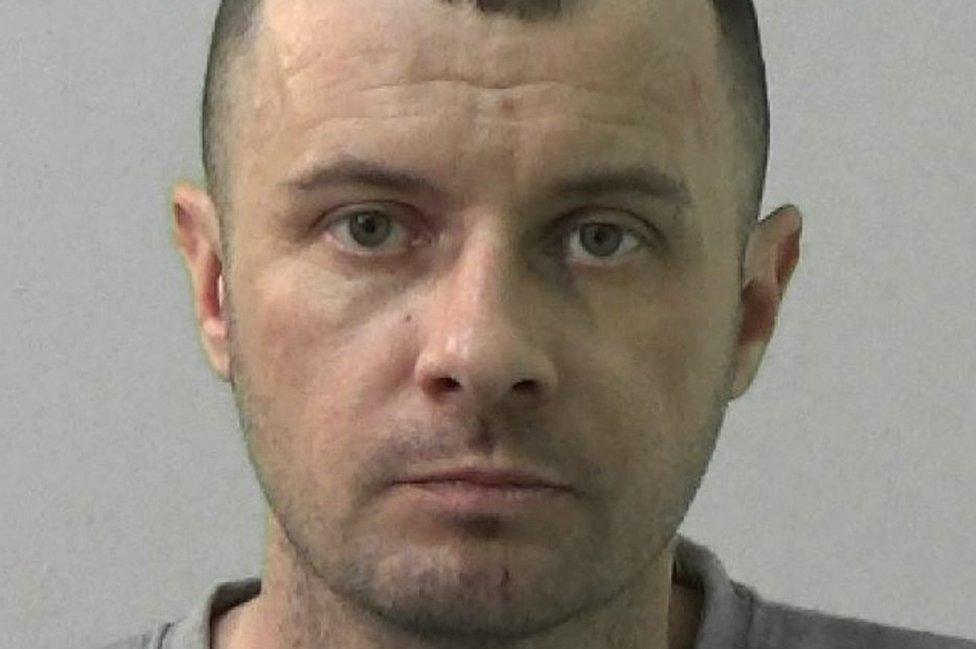 Toby Kelly mugshot, a man in a grey jumper looks at the camera