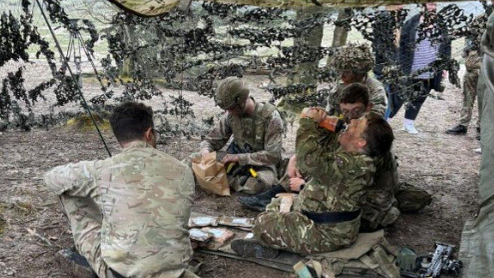 Noah eating rations on exercise with other troops