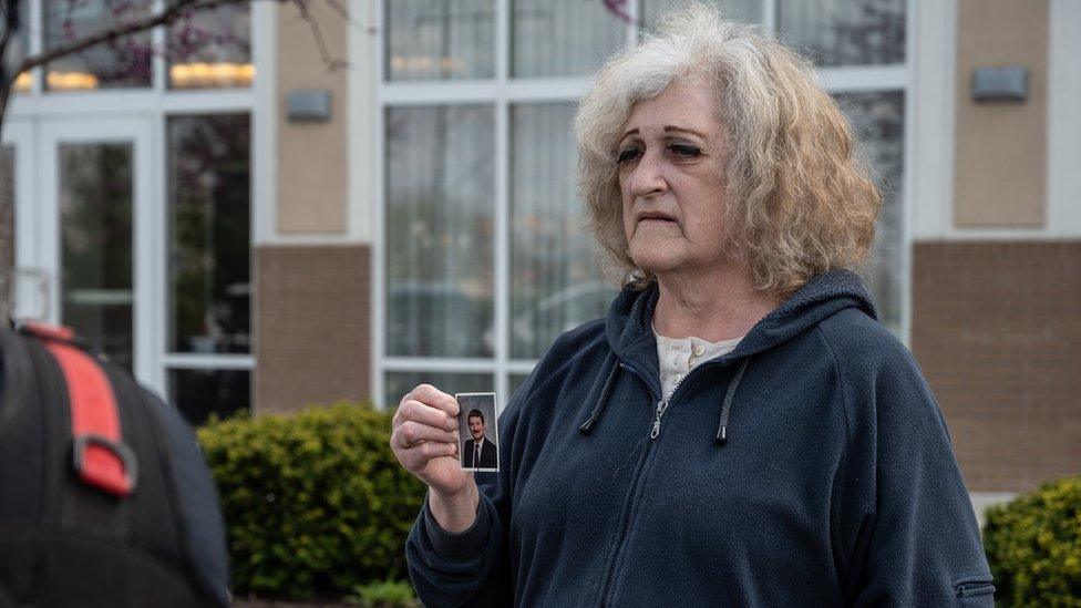 Mary Carol Weisert shows a photograph of her husband John Weisert, who was killed in the attack