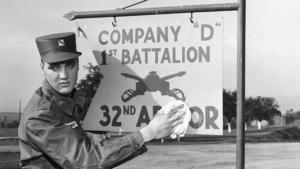 Elvis Presly cleaning a sign in Germany