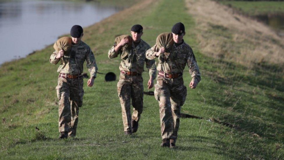 British Army soldiers carry sandbags in Stainforth