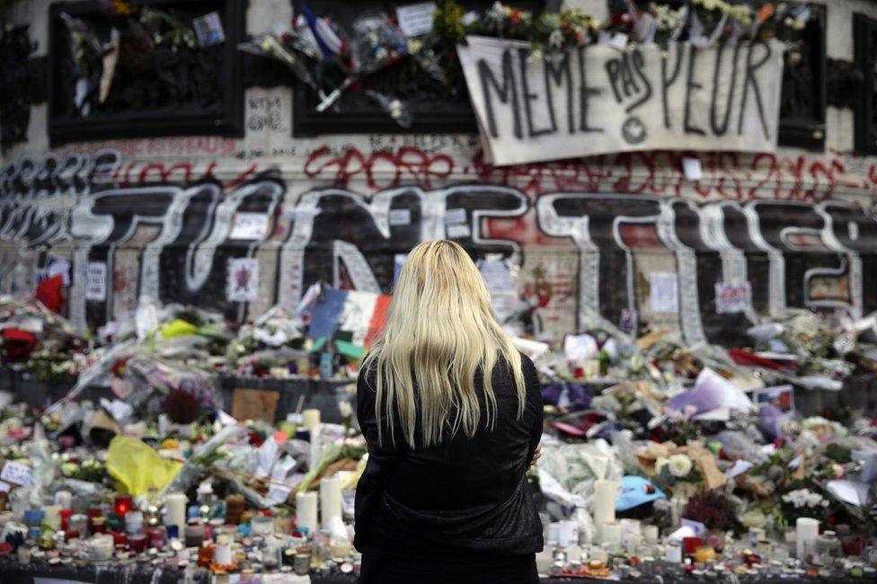 A woman stands in front of a makeshift memorial at the Place de la Republique in Paris (17 November 2015)