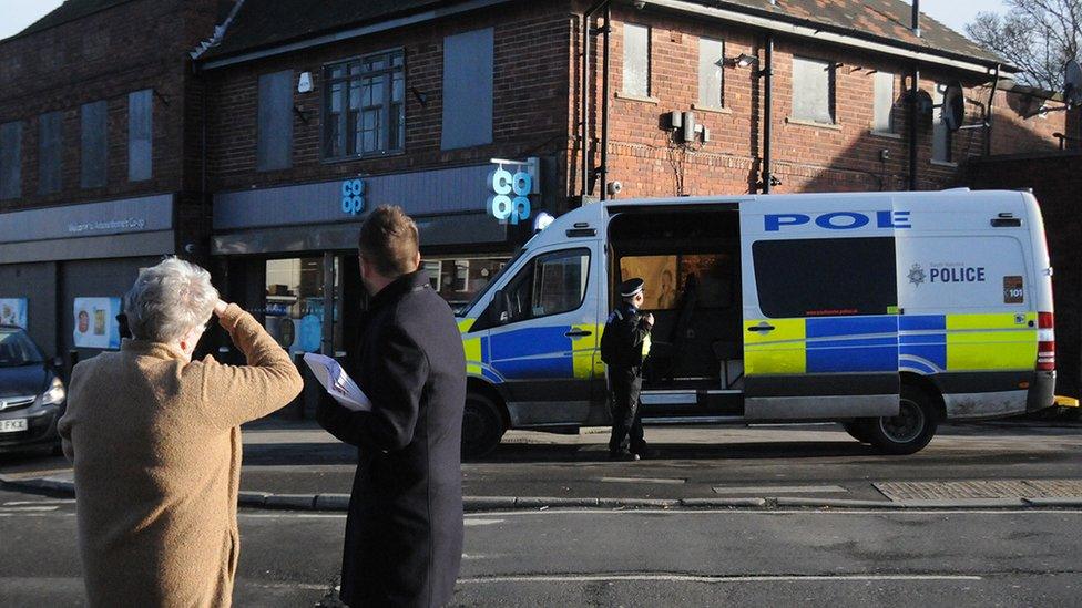 Two people looking at the scene of a shooting