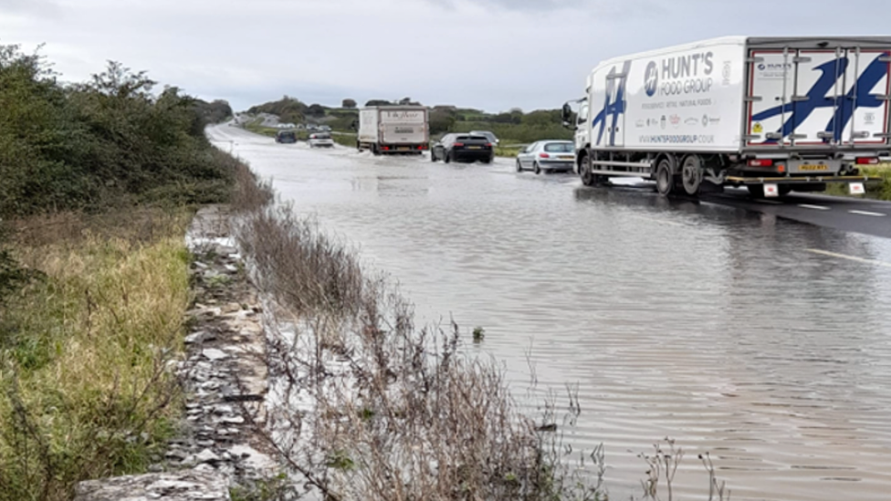 A flooded road with cars on the road