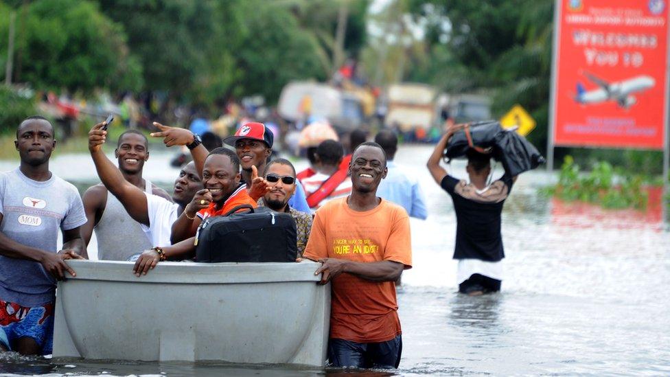 People trying to join Monrovia airport are being transported onto a canoe, on July 1, 2016, after heavy rains cut the only road accessing Liberia"s main airport. Heavy rains have cut the only road access to Liberia"s main airport, leaving travellers to cross some sections by canoe, passengers told AFP on July 1.