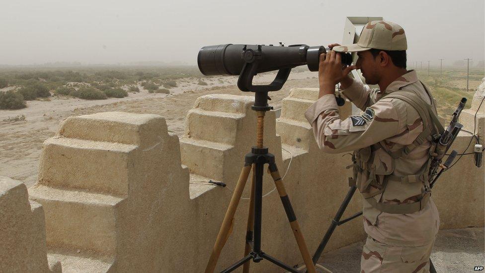 Iranian border guard looks through binoculars (file photo)