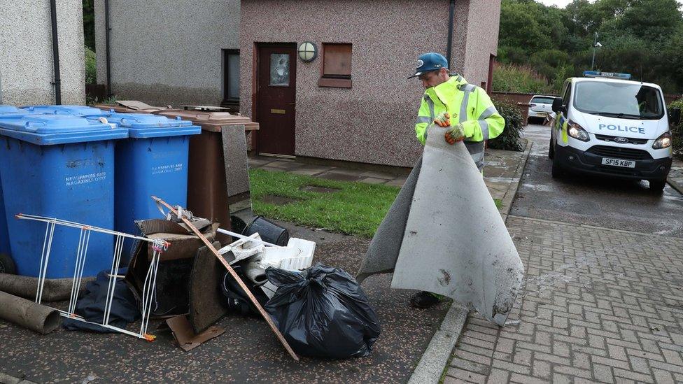 A worker cleaning up after flooding in Pyothall Court in Broxburn, West Lothian.