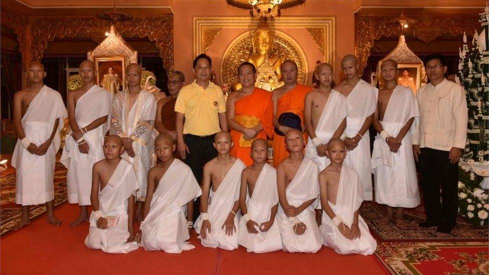 The rescued 11 Thai boys and members of "Wild Boars" football team together with their coach wearing white robes pose with Buddhist monks at the Phra That Doi Wao Buddhist temple in the Mae Sai district of Chiang Rai province during the religious ordination ceremony on July 24, 2018.