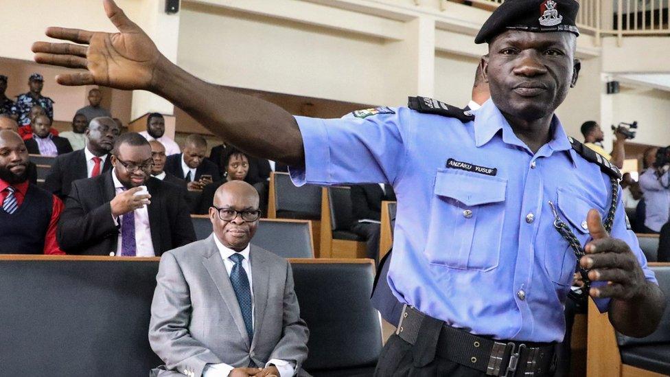 Policeman stands in front of Walter Innoghen