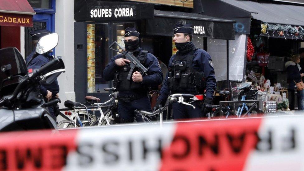 Armed police officers secure the perimeter on Rue d'Enghien following the shooting incident, 23 December