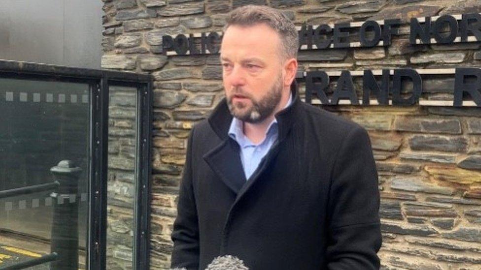 SDLP MP Colum Eastwood speaking outside Strand Road police station.