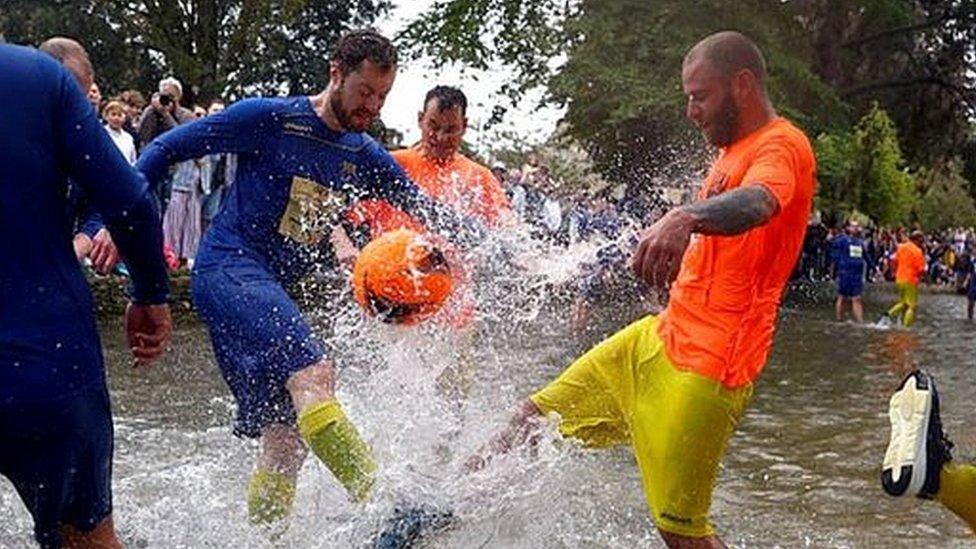 A group of footballers in a river