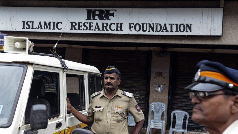 Mumbai Police personnels stands outside the closed office of Islamic Research Foundation