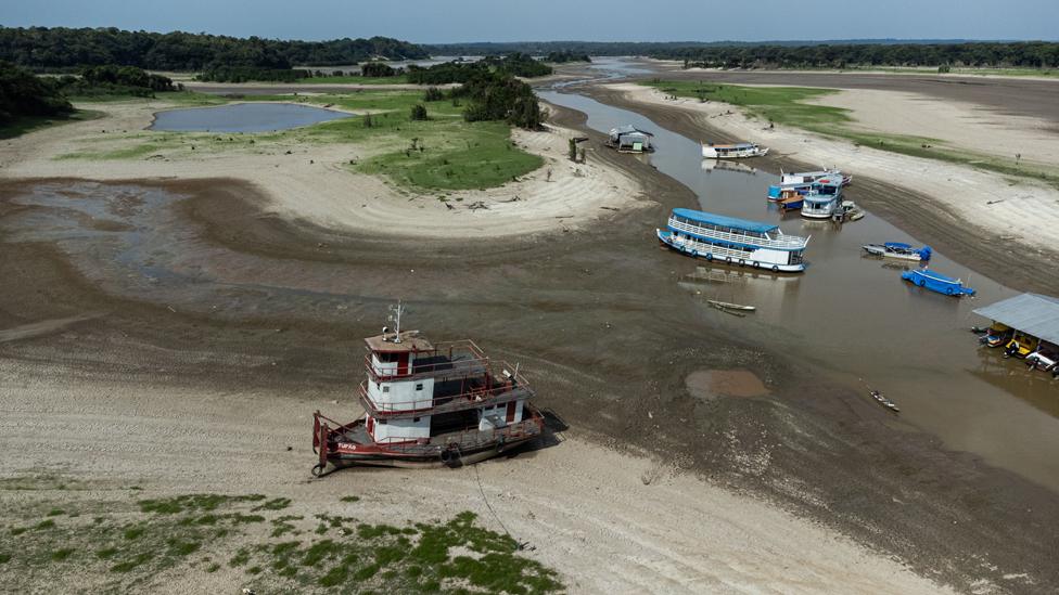 An aerial photograph taken by drone shows boats and houses stranded in a dried up area of Lago do Puraquequara lake, in Manaus, Amazonas, Brazil, 06 October 2023