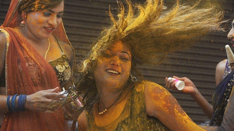 Revellers smeared in coloured powder dance during the Holi celebrations, the Hindu spring festival of colours, in Hyderabad on March 17, 2022.