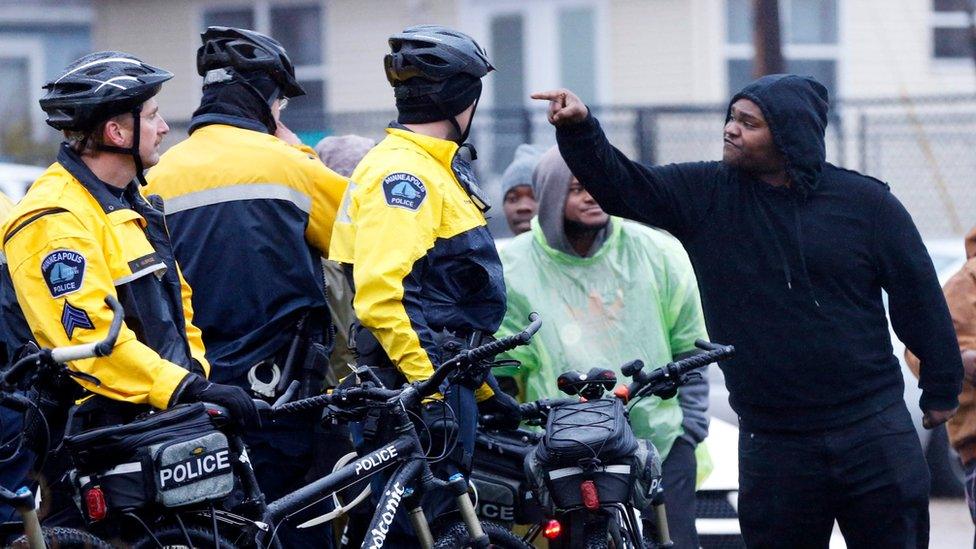 A man pointing at police officers