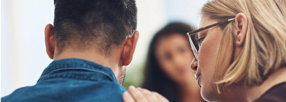 Shot of a wife consoling her husband during a counseling session with a therapist