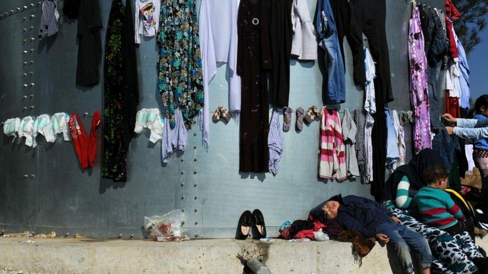 A child sleeps under laundry at the migrant and refugee registration camp in Moria village on the northeastern Greek island of Lesbos