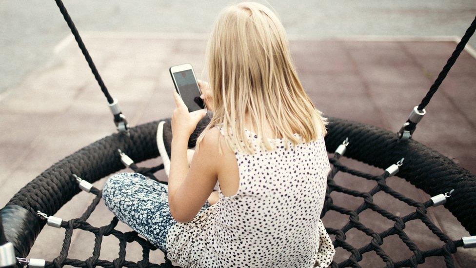 A stock image of a child using a smartphone