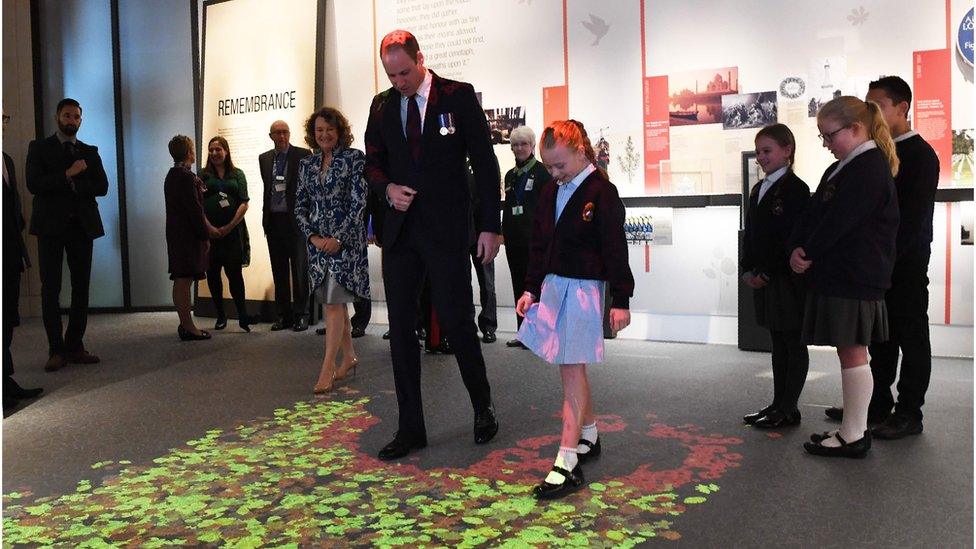 Prince William walks through an interactive light display as he tours the centre