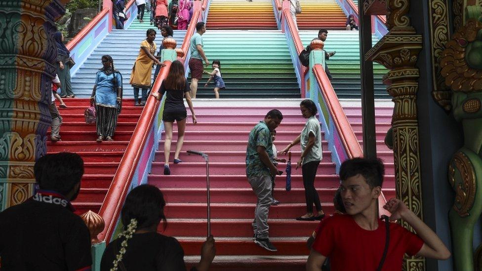 Visitors walk on the colourful stairs at Malaysia's Batu Caves