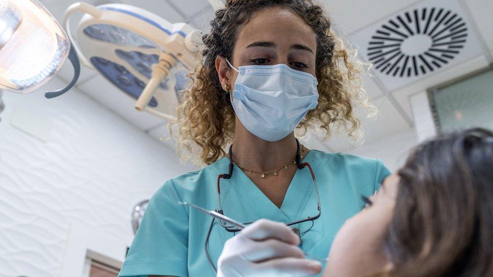 Dentist examines young girl