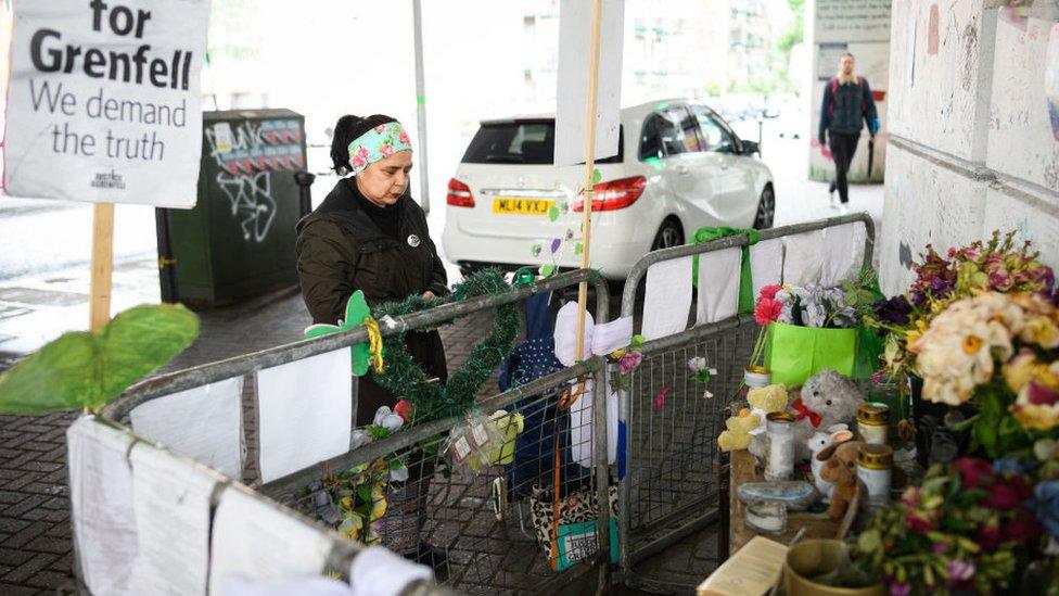 One woman says a prayer after attaching a tribute to a railing near the tower