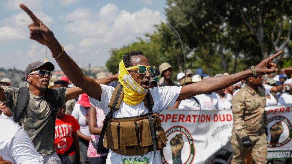 Member of Operation Dudula gestures as he sings and chant anti-foreigners slogans