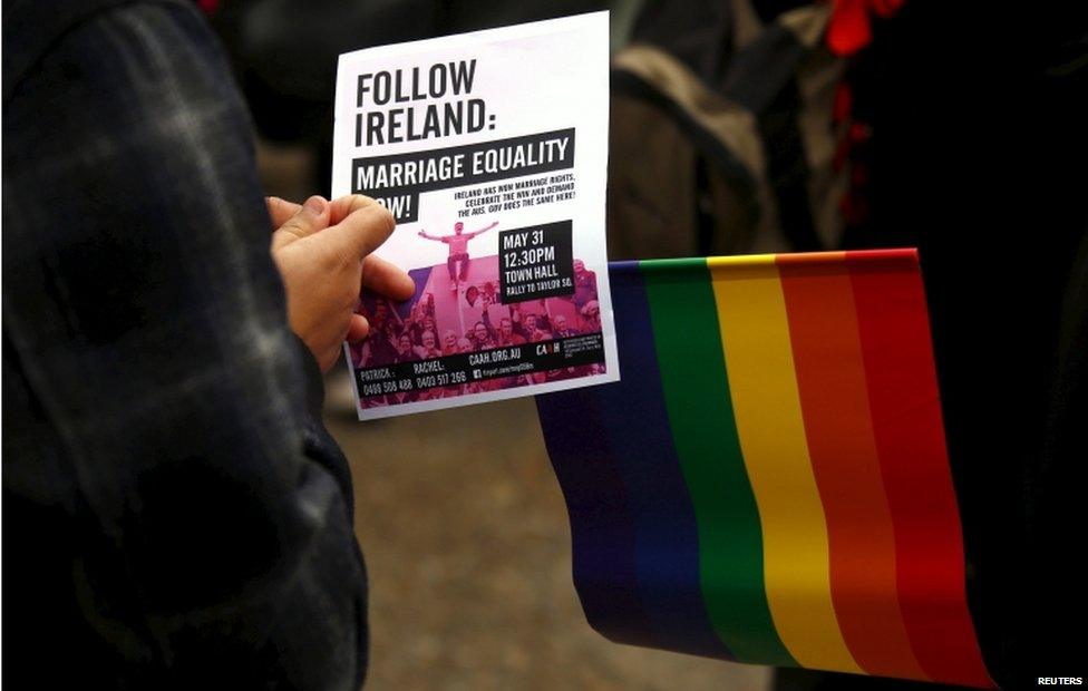 A gay-rights activist holds a pamphlet and flag during a rally supporting same-sex marriage in Sydney, Australia 31 May 2015.