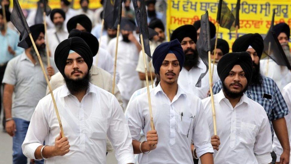 Sikh members of Shiromani Gurdwara Prabandhak Committee (SGPC) and other organizations, hold black flags during a peaceful protest over the alleged desecration of the Sikh holy book at a village near Tarn Taran, in Amritsar, India, 20 October 2015.