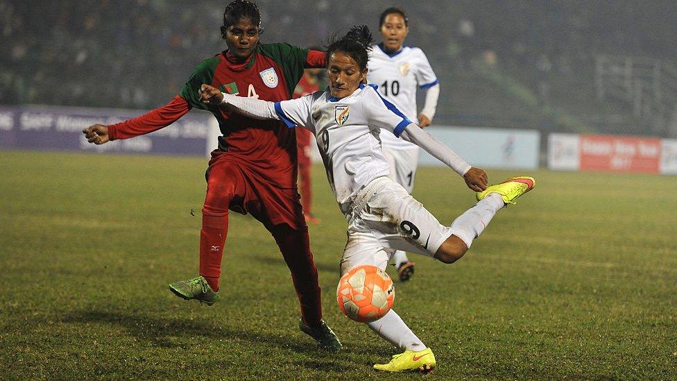 Indian footballer Kamala Devi Yumnam (C) vies for the ball with Bangladesh footballer M Nargis Khatun (L) as Indian captain Bala Devi Ngangom looks on during the final of the South Asian Football Federation (SAFF) women's football championship at the Kanchanjungha Stadium in Siliguri on January 4, 2017.