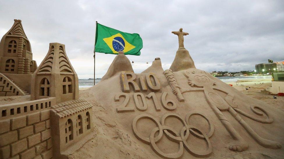 A general view of the Olympic Rings, flag, Vinicius and Christ the Redeemer made into a sand sculpture on the beach during the Olympics preview day