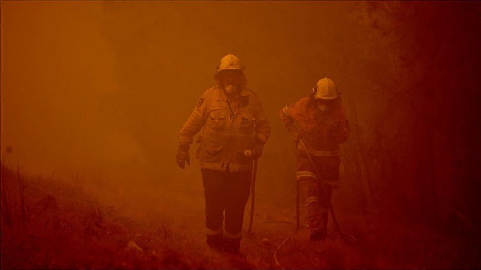 Firefighters tackle a bushfire in thick smoke in the town of Moruya, south of Batemans Bay, in New South Wales on 4 January, 2020.