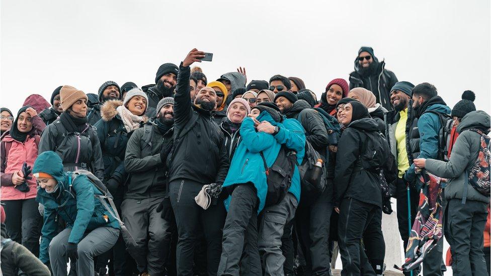 A group of walkers on top of a peak