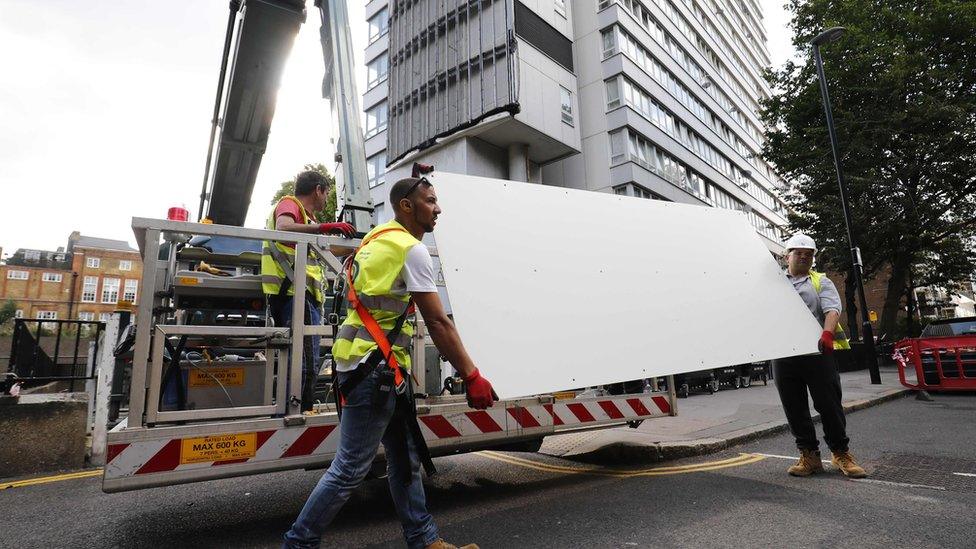 Workers removing cladding from a London tower block